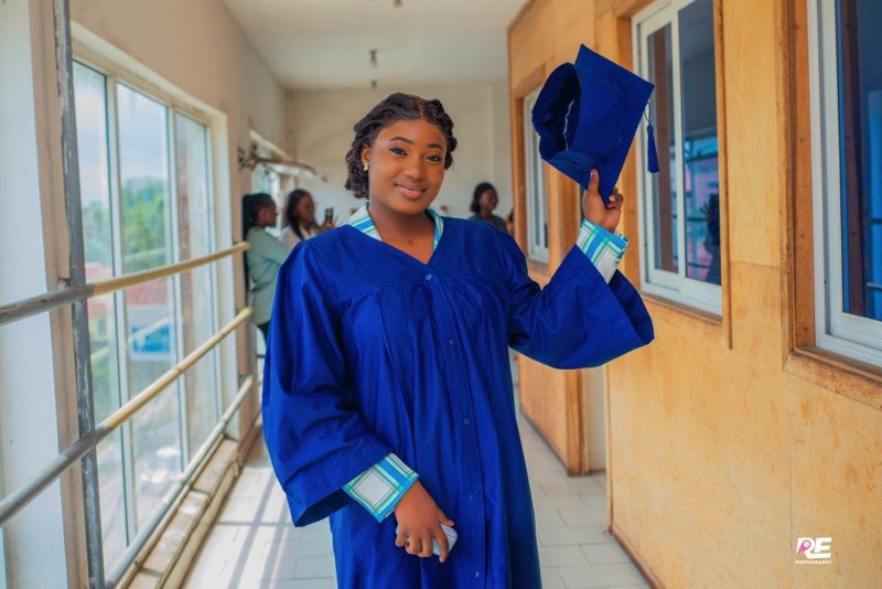 Jeune diplômée en toge bleue, toque à la main