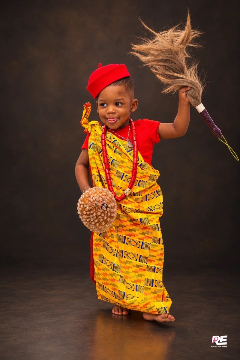 Enfant en tenue traditionnelle, chasse-mouches à la main, en studio