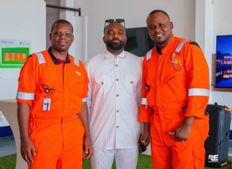 Trois collaborateurs posent sur un site de SLB, deux d’entre eux en combinaison orange